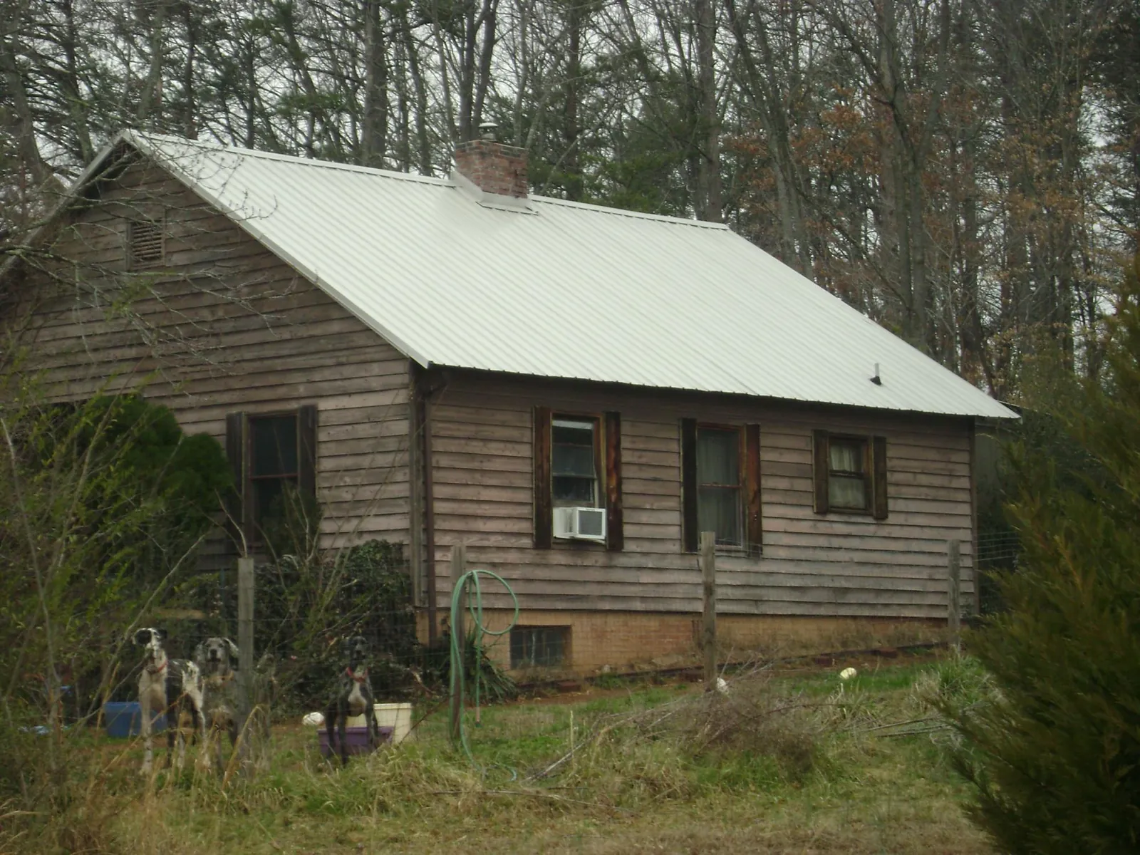 White metal roof on an old wood sided farmhouse, from a Metal Roof Installation job in Whitesboro